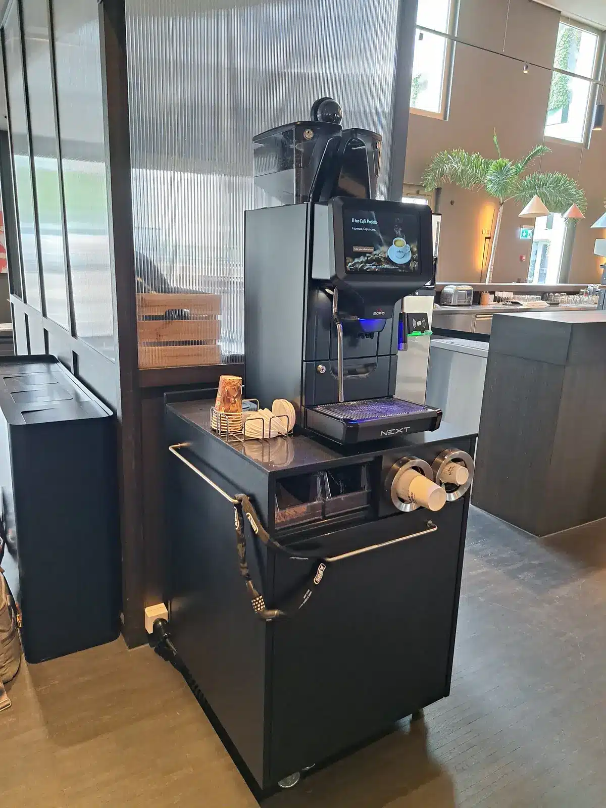 Machine à café professionnelle d'Egro Suisse AG : du café fraîchement préparé coule dans une tasse en verre.